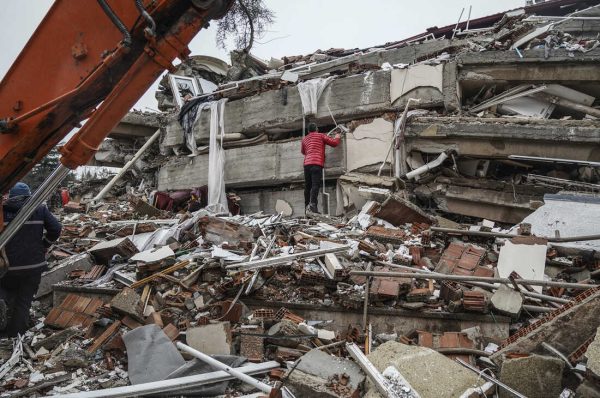 A man searches for people  in the rubble of a destroyed building in Gaziantep, Turkey, Monday, Feb. 6, 2023. A powerful quake has knocked down multiple buildings in southeast Turkey and Syria and many casualties are feared. (AP Photo/Mustafa Karali)